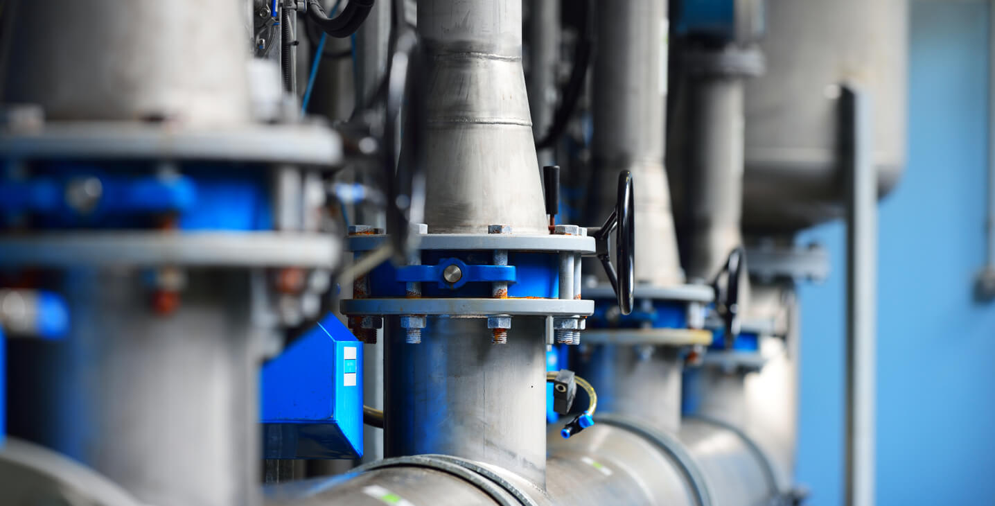 Large Industrial water treatment unit and pipework in a facility plant room. 