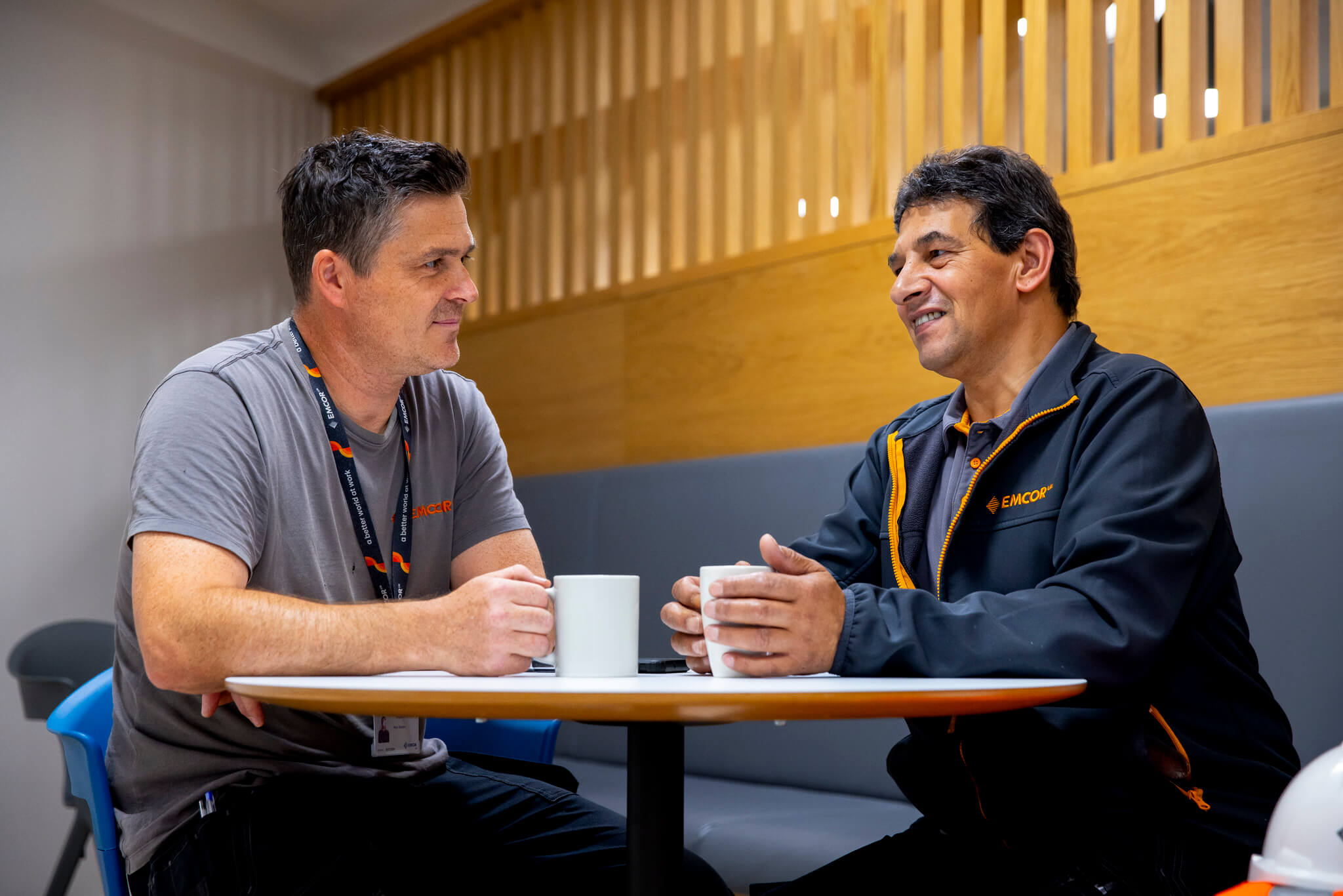 Two colleagues sat having a hot drink and talking. 