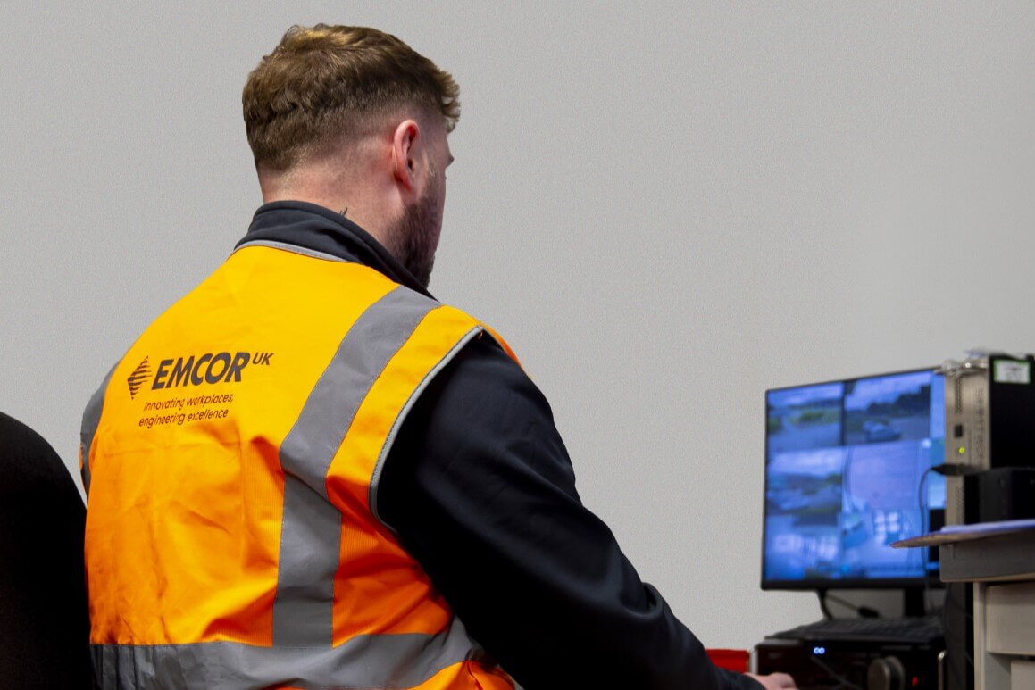 Security guard monitoring CCTV footage on a computer screen. 