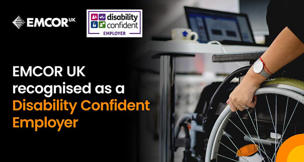 EMCOR UK highlighting their recognition as a disability confident employer - along with an image showing a person in a wheelchair working at a desk.