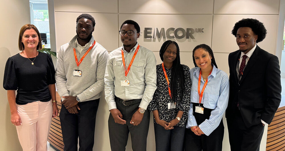 EMCOR UK's Cheryl McCall standing in the lobby entrance with six new interns from the 10,000 Black Interns programme.