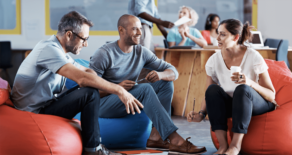 Three people in a work setting having a discussion