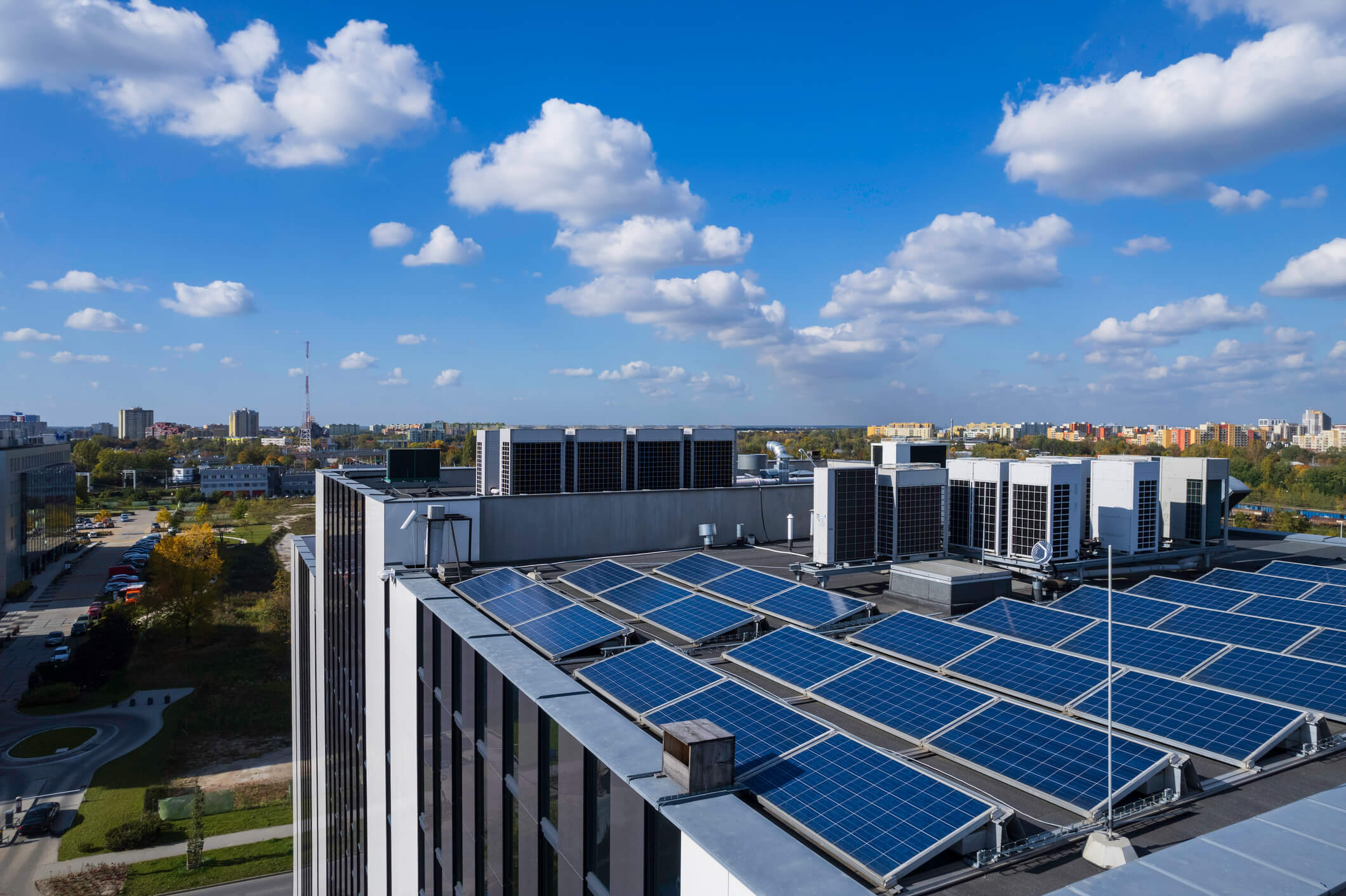 Aerial shot of solar panels on the roof of a building on a sunny day. 