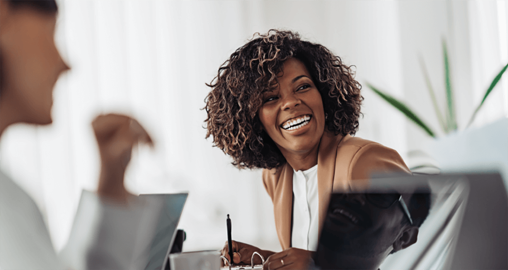 Female employee smiling while having a discussion in a corporate setting